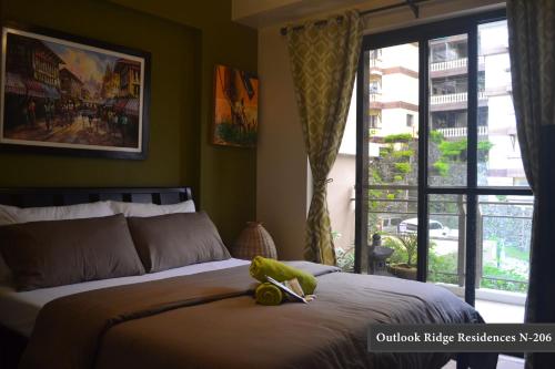 a bedroom with a bed with a stuffed animal on it at Outlook Ridge Residences - North in Baguio