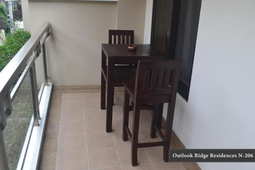 a dining room table and chairs on a balcony at Outlook Ridge Residences - North in Baguio