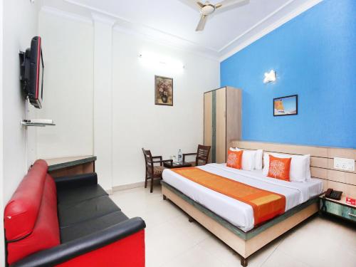 a hotel room with a bed and a red couch at Hotel Arneja in Jalandhar
