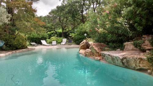 - un jardin avec une piscine et des chaises dans l'établissement La Bousquatière, à Piolenc