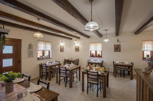 a restaurant with wooden tables and chairs and windows at Rooms Imperial House in Plitvička Jezera