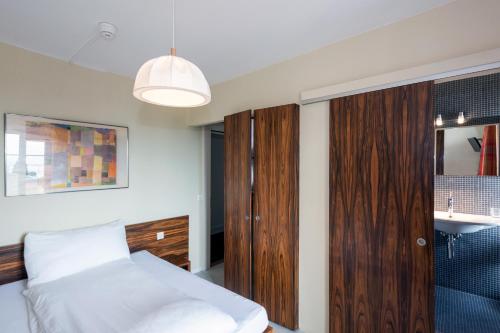a bedroom with a bed and a wooden closet at Hôtel du Cheval-Blanc in Saint-Blaise