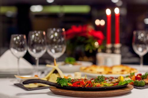 a table with a plate of food and wine glasses at Borjomi Likani Health & Spa Centre in Borjomi