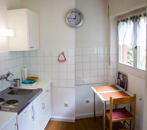eine Küche mit einem Tisch und einer Uhr an der Wand in der Unterkunft Appartementhaus Martin in Badenweiler