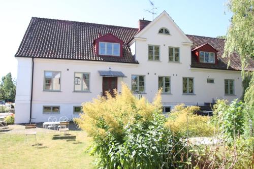 ein großes weißes Haus mit rotem Dach in der Unterkunft Mellby 11 Bed & Breakfast in Kivik