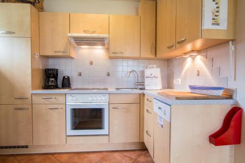a kitchen with wooden cabinets and a stove top oven at Mountain View near Kaprun - Steinbock Lodges in Piesendorf