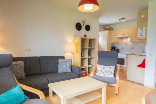 a living room with a couch and a table and a kitchen at Mountain View near Kaprun - Steinbock Lodges in Piesendorf