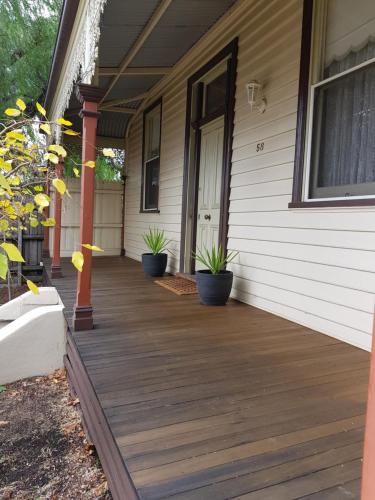 a porch of a house with potted plants on it at Myers CBD in Bendigo