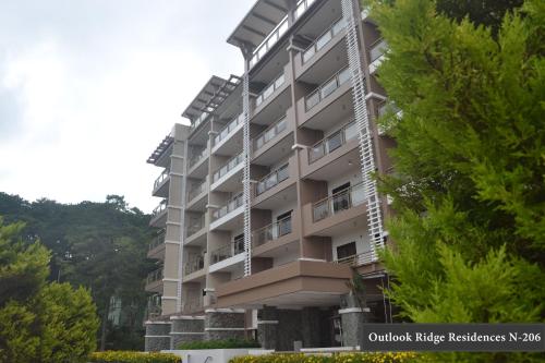an apartment building with trees in front of it at Outlook Ridge Residences - North in Baguio