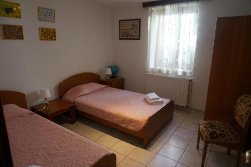 una piccola camera con due letti e una finestra di Magnolia a Agios Nikolaos