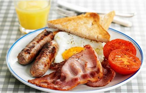 a plate of breakfast food with sausage eggs bacon and toast at Sanderlay Guest House in Kirkwall