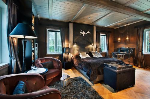 a bedroom with a bed and a table and chairs at Herangtunet Boutique Hotel in Heggenes