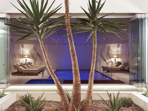 a lobby with two palm trees and a pool at Golden Sun Resort - Adults Only in Kalamaki