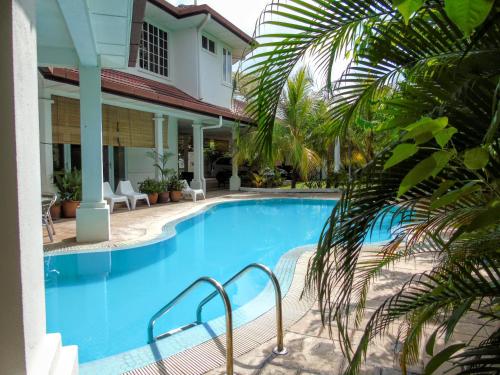 a swimming pool in front of a house at Rumah Putih B&B near KLIA in Sepang