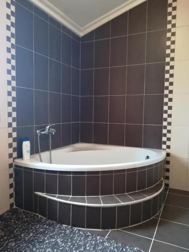 a bath tub in a bathroom with blue tiles at Casa Serra da Lapa in Viseu