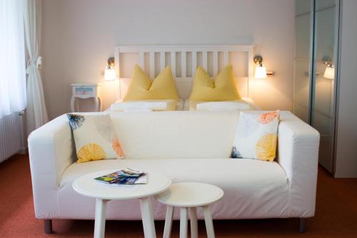 - un salon avec un canapé blanc et un lit dans l'établissement Appartementhaus Martin, à Badenweiler