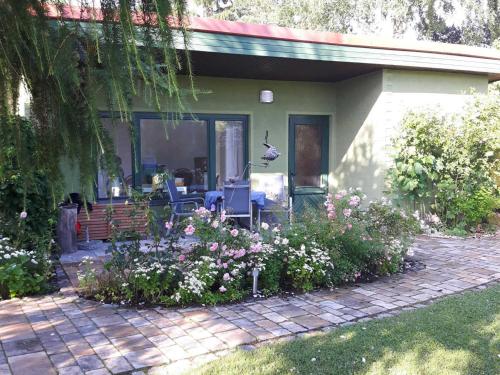 a house with a flower garden in front of it at Ferienbungalow Haus Rolf _ Objekt in Papendorf