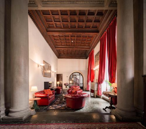 ein Wohnzimmer mit roten Möbeln und roten Vorhängen in der Unterkunft Hotel Torre Guelfa Palazzo Acciaiuoli in Florenz
