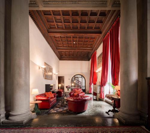 una sala de estar con muebles rojos y cortinas rojas. en Hotel Torre Guelfa Palazzo Acciaiuoli en Florence