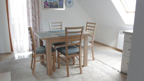 a wooden table and chairs in a room at Siedlisko Kępina Zdrój in Ostrów
