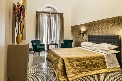 ミラッツォにあるManzoni 46 - Ospitalità sicilianaのベッド1台と椅子2脚が備わるホテルルームです。