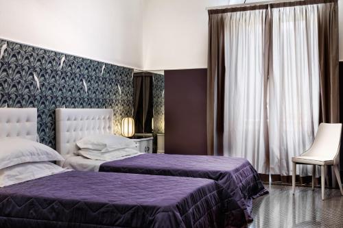 a hotel room with two beds and a window at Manzoni 46 - Ospitalità siciliana in Milazzo