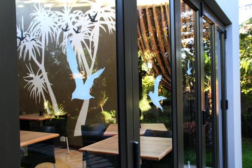a window of a restaurant with birds on it at Appledew Guesthouse in Standerton