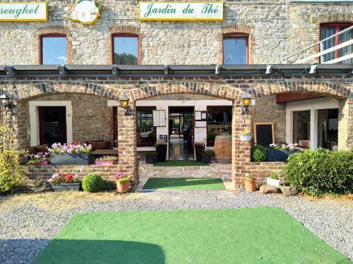 a brick building with an entrance with a green lawn at Le Jardin du Thé Bord de la Meuse in Namur