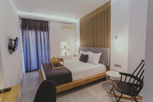 a bedroom with a bed and a desk and a chair at Hotel Papagalos in Neos Marmaras