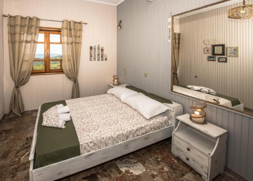 Un dormitorio con una cama y un espejo grande. en Kyparissos Apartment I, en Kissamos