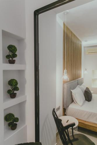 a mirror in a bedroom with a bed and a chair at Hotel Papagalos in Neos Marmaras