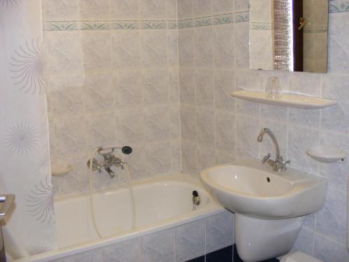 bagno con lavandino, vasca e servizi igienici di Hotel Fama a Hódmezővásárhely