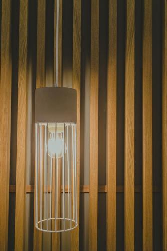 a light fixture hanging from a wall with wood panels at Hotel Papagalos in Neos Marmaras