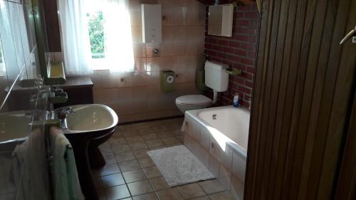 a bathroom with a tub and a toilet and a sink at Mica in Senj