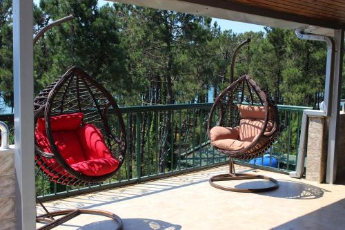 two chairs sitting on a porch with a railing at Golden Fleece Hotel in Ureki