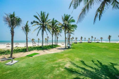 a park with palm trees and the beach at Sunshine Apartment in 5* resort in Da Nang