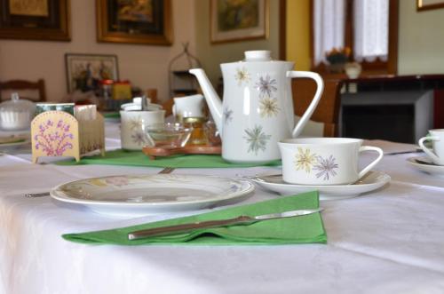 a table with plates and cups on a table at B&B Marie Therese in Torreano