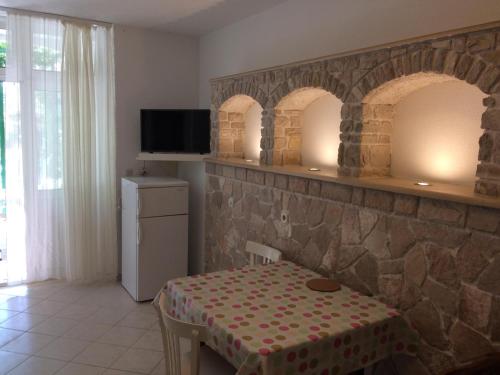 a room with a table and two arches on a wall at Apartments Radić in Bol