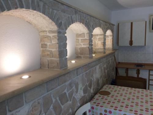 a kitchen with two arched windows and a table at Apartments Radić in Bol