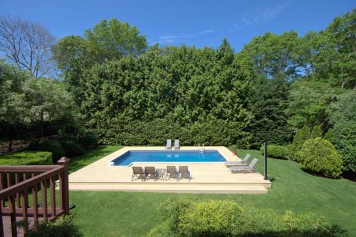 una piscina en un patio con sillas alrededor en Nice 4bdr all Q size,IG Pool,Billiard, en Hampton Bays