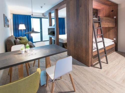 a living room with a dining table and a bunk bed at Spreewelten Hotel in Lübbenau