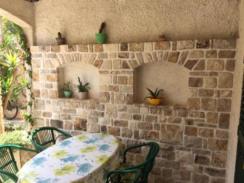 a table and chairs in front of a brick wall at Apartments Radić in Bol
