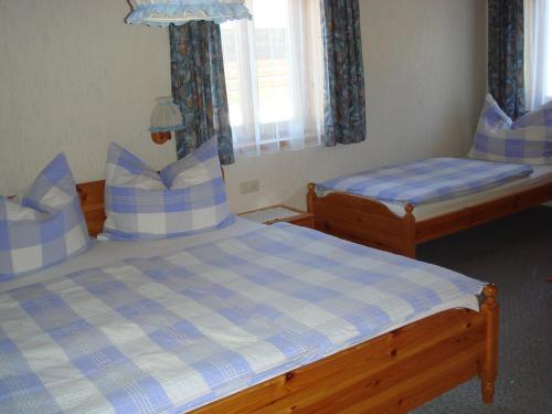 a bedroom with two beds with blue and white sheets at Brandstättgut in Altenmarkt im Pongau