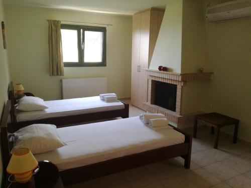 a room with three beds and a fireplace at Achladi Beach in Achladi