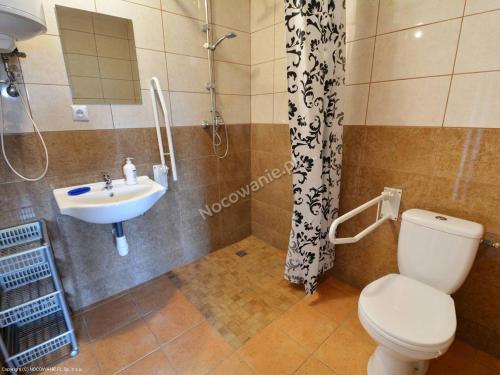 ein Bad mit einem WC und einem Waschbecken in der Unterkunft Domki u Jagody in Sarbinowo