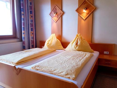 a bedroom with two beds with white blankets and lights at Gasthof Janits in Burgau