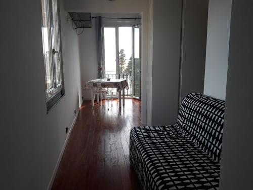 uma sala de estar com um sofá, uma mesa e uma janela em House Orizzonte - Casa Bianca em Gênova
