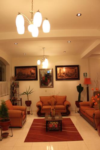a living room with orange couches and a table at Sol Plaza Hotel in Puno