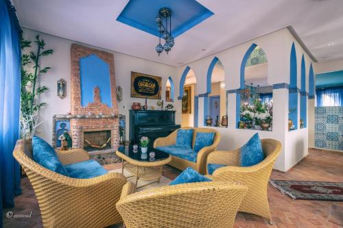 a living room with chairs and a fireplace at Dar Ba Sidi & Spa in Chefchaouen