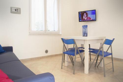 a living room with a table and blue chairs at Appartamento L'ONDA - 3 in Fezzano